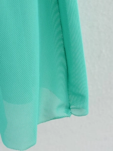 Detaillierte Makroansicht des blaugrünen Netzgewebes mit feiner Kantennaht am Kleid
