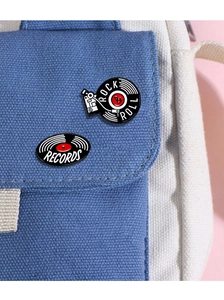 Detailed view of vintage record player and vinyl enamel pins on a canvas bag