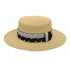 Detail of straw hat with glitter band and pearls on a flat top summer sun hat