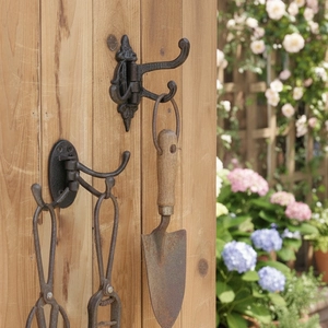 Vintage three-tier cast iron swivel wall hook mounted on a wooden door for home decor