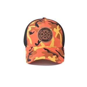 Gros plan du patch rond en cuir gravé Enjoy Life sur cette casquette de style camouflage