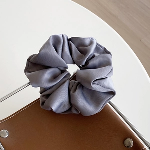 Glossy grey satin scrunchie hair tie with elegant silk-like pleated texture