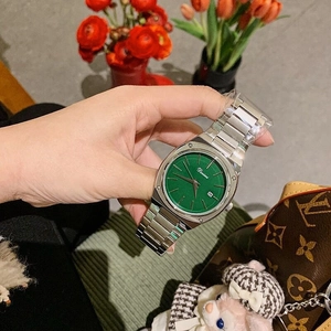 Detail of Dimini silver steel watch with green dial and calendar on female wrist