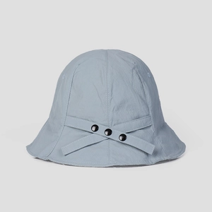 Detail showing the gray-blue textured fabric and button strap on a sun protection bucket hat