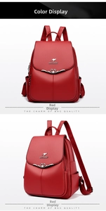 Detail view of red lychee textured leather backpack with metal logo and heart ornament