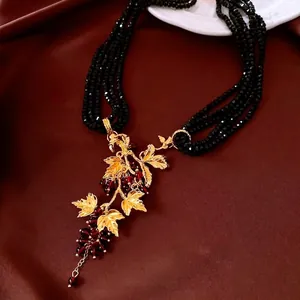 Vintage multilayer black bead necklace with gold grape leaf pendant and red fruit accents