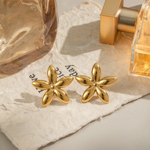 Détail de boucles d'oreilles fleurs en acier titane plaqué or 18K avec fini poli
