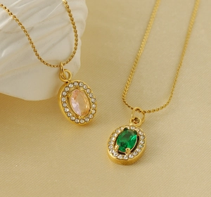 Dettaglio di collane in oro 18K con pietre ovali smeraldo e rosa e bordo in zirconi