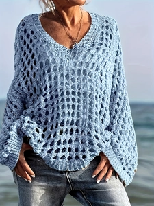 Détail d'un cache-maillot bleu clair en maille ajourée avec col en V et motif de losanges