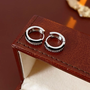 Macro detail of silver hoop earrings with black enamel inlay and pave cubic zirconia