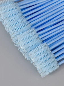 Macro shot of 50 disposable sky blue eyelash brushes with spiral nylon bristles