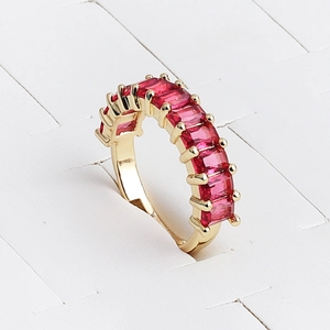 Detail view of gold ring with rectangular red zircon stones on a white display stand