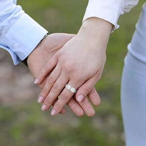 Detail of silver embossed rotating rings worn by a couple for Bohemian style jewelry gift