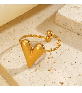 Detailed view of a gold heart open ring with textured band on a stone background