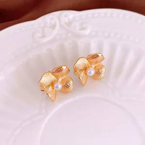 Vintage flower pearl earrings with gold brushed metal petals and central white pearl