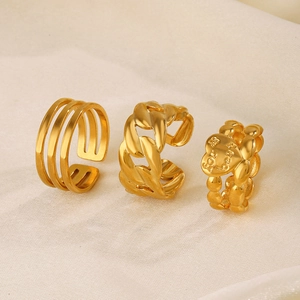 Three gold plated stainless steel rings including layered, chain and heart designs
