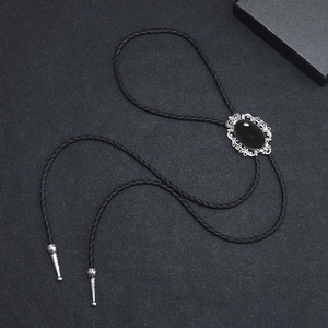 Retro bolo tie featuring black oval stone in silver frame with braided leather cord