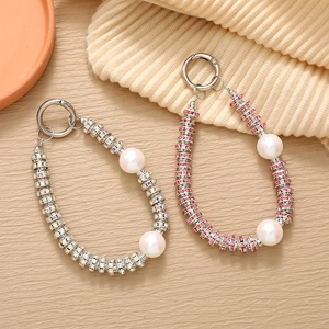 Close-up of beaded phone charms with sparkling rhinestones and elegant pearls