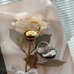 Minimalist teardrop open rings in polished gold and silver finish set on a floral card