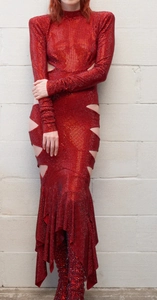 Détail de robe à paillettes rouges avec découpes latérales et ourlet sirène irrégulier