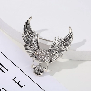 Macro detail of winged skull brooch with sparkling rhinestones and vintage silver finish
