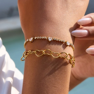 Elegant gold-plated heart tennis bracelets set with sparkling cubic zirconia on female wrist