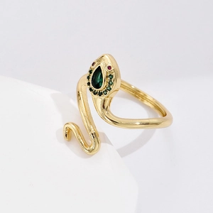 Elegant gold-plated snake ring with green and red zircon stones on a white background