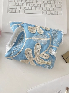 Light blue cotton cosmetic bag with floral embroidery and tassel edge for storage