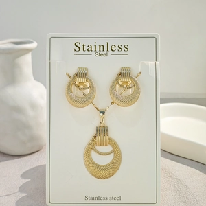 Detail of vintage geometric gold stainless steel jewelry set with mesh round pattern
