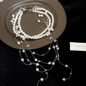 Detail of layered pearl necklace with silver tassels in a vintage French style