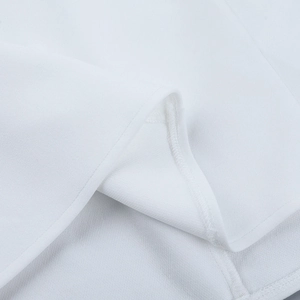 Close-up of white woven fabric texture and precision hem stitching on the backless dress