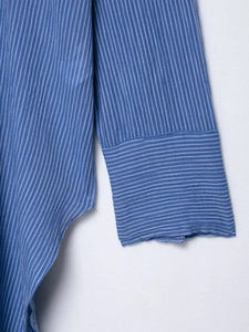 Gros plan d'une chemise à rayures bleues et blanches montrant les coutures et la texture