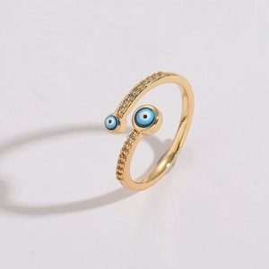 Macro detail of gold-plated evil eye ring with blue enamel and sparkling crystals