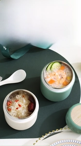 Close-up of insulated stainless steel breakfast cups with wood grain lids for soup and milk