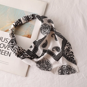 Detail view of monochrome paisley chiffon hair bandana with elastic band on cotton background