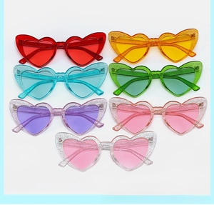 Detailed flat lay of heart shaped glitter sunglasses in seven vibrant transparent colors