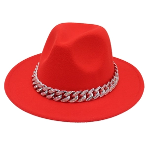 Detail of red fedora hat featuring a sparkling rhinestone-embellished silver cuban chain