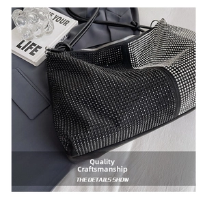 Detail shot of a black tote bag with shimmering black and white rhinestones and slim strap