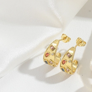 Detail of gold-plated C-shaped earrings with colorful gemstones and vintage bead edges