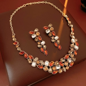 Detailed view of vintage gold necklace and teardrop earrings set with amber crystals