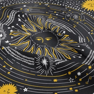 Close-up of celestial mandala tapestry showing sun and star patterns on textured fabric