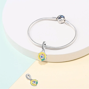 Silver snake chain bracelet featuring colorful enamel Ferris wheel charm on white stand