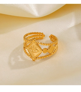 Detailed close-up of golden evil eye ring with rhombus frame on silk fabric
