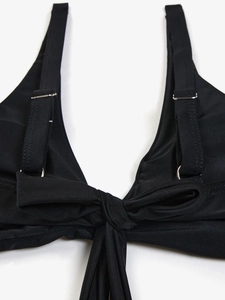 Dettaglio del top bikini nero con spalline regolabili e un grande fiocco sulla schiena