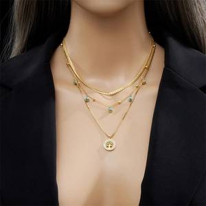 Multilayer gold necklace with turquoise beads and tree of life pendant on a model