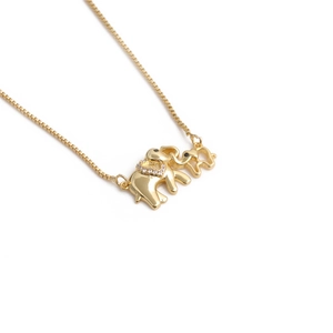 Minimalist gold elephant pendant necklace with zircon heart inlay on a white background