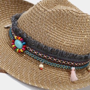 Detail of straw hat featuring sequins, colorful beads, turquoise stone and tassels