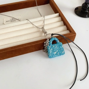 Gros plan du pendentif sac en strass bleus avec des glands argentés de style raisin