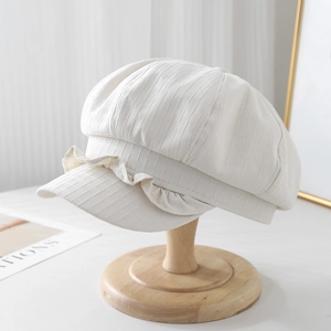 Breathable linen octagonal cloud hat with ruffled brim on a wooden display stand