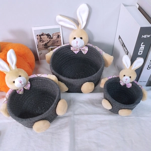 Three-piece set of dark grey woven storage baskets with plush bunny decor in various sizes